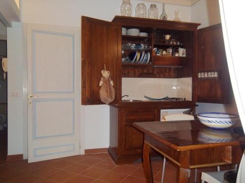 アッシジにあるVia San Rufino 10 Apartmentのキッチン(テーブル付)、木製キャビネット