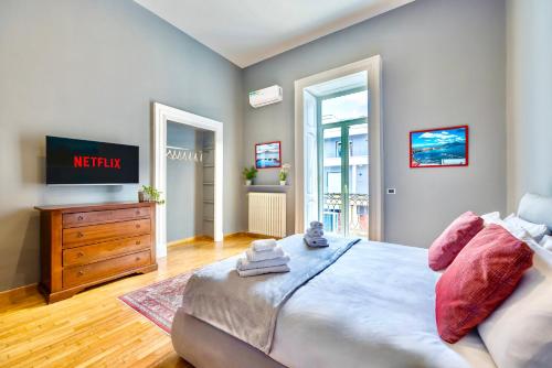 ein Schlafzimmer mit einem Bett, einer Kommode und einem TV in der Unterkunft Quadrifoglio Relais Partenope vista Capri in Neapel