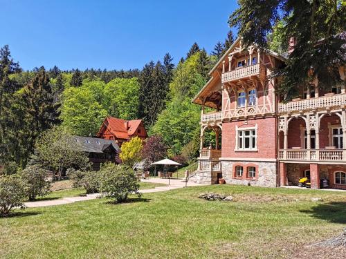 una gran casa de ladrillo con un gran patio en Willa Trebla en Miedzygorze