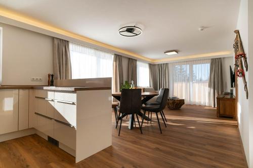 a kitchen and dining room with a table and chairs at Waldrand Apartments in Ramsau am Dachstein
