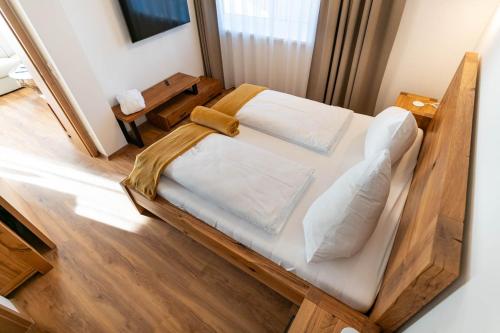 a large wooden bed in a room with wooden floors at Waldrand Apartments in Ramsau am Dachstein
