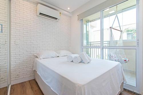 a white bedroom with a bed with towels on it at Studio Charmoso Alto da Boa Vista - Próx CGH e Transamérica in Sao Paulo