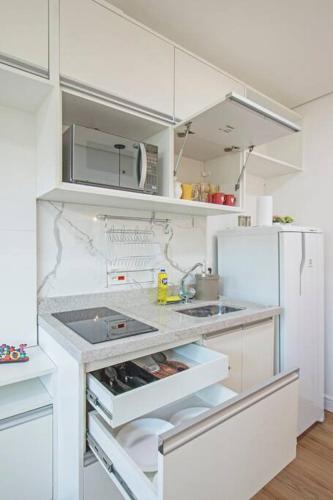 a kitchen with white cabinets and a white refrigerator at Studio Charmoso Alto da Boa Vista - Próx CGH e Transamérica in Sao Paulo