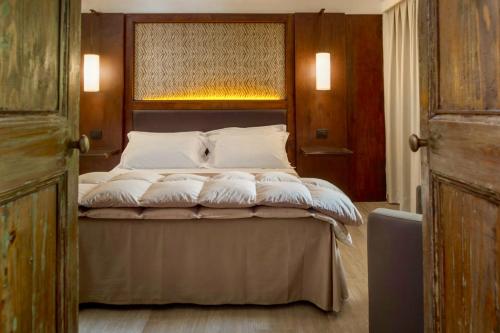 a bedroom with a large bed with white pillows at Baglio La Porta by Geocharme in San Vito lo Capo