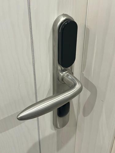 a metal door handle on a white door at Hostal ROM Familiar in Roses