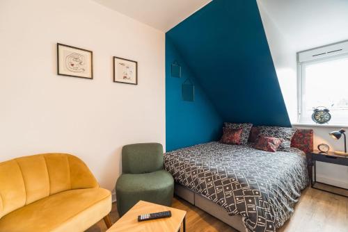 a bedroom with a bed and a chair at Studio central et charmant Guingamp centre in Guingamp