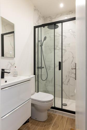 une salle de bain blanche avec douche et toilettes dans l'établissement Elégance méditerranéenne 3p, avec Parking, à Juan-les-Pins