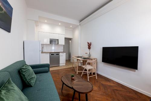 un salon avec un canapé vert et une cuisine dans l'établissement Elégance méditerranéenne 3p, avec Parking, à Juan-les-Pins