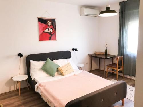 a bedroom with a bed and a table with a chair at Lukenda rooms in Pakoštane