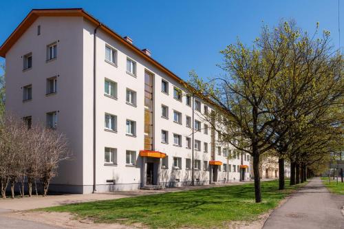 a white building with a tree in front of it at Ernakodu in Pärnu
