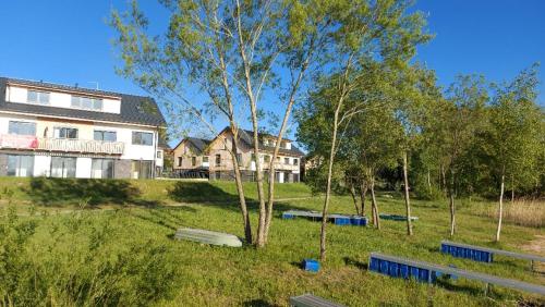 un parc avec des bancs en face d'une maison dans l'établissement Lipno Apartments BERGMAX, Ski Areál Lipno 16min dojezd - Resort Malé Lipno s terasou a zahrádkou, parking free, à Černá v Pošumaví