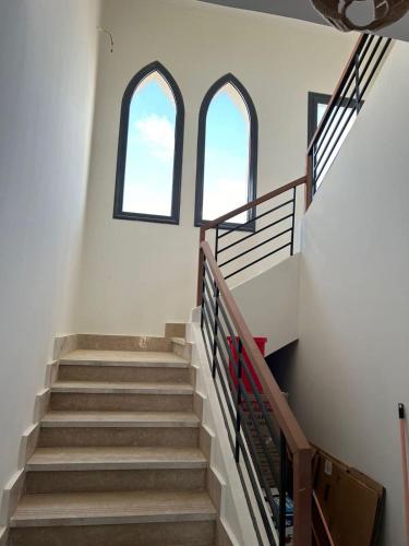 un escalier avec deux fenêtres dans un bâtiment dans l'établissement GAIA North Coast, à Marsa Matruh