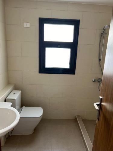 La salle de bains est pourvue de toilettes et d'une fenêtre. dans l'établissement GAIA North Coast, à Marsa Matruh