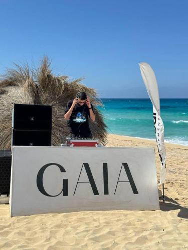 une personne prenant une photo d'un panneau sur la plage dans l'établissement GAIA North Coast, à Marsa Matruh