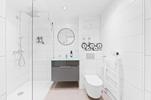 a white bathroom with a toilet and a sink at Kingsize Bett, Naturidylle, Netflix, Großräumig in Pforzheim