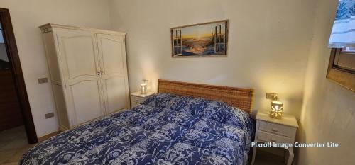 サン・パスクアーレにあるAppartamento Costa Smeraldaのベッドルーム1室(青と白のベッドカバー付)