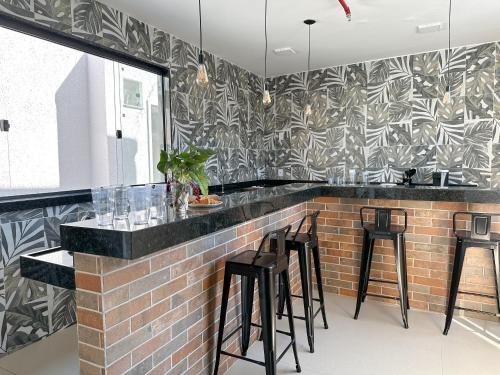 a kitchen with a bar with black and white wallpaper at CoVivere - RJ in Rio de Janeiro