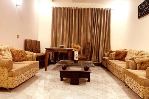 a living room with two couches and a coffee table at Exotic Hill View Stay in Karachi