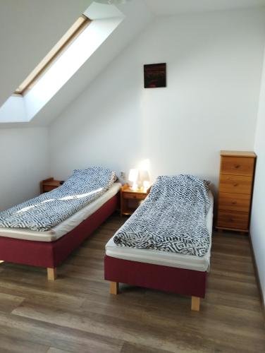 two twin beds in a room with a attic at Noclegi Pod Dębem in Skawina