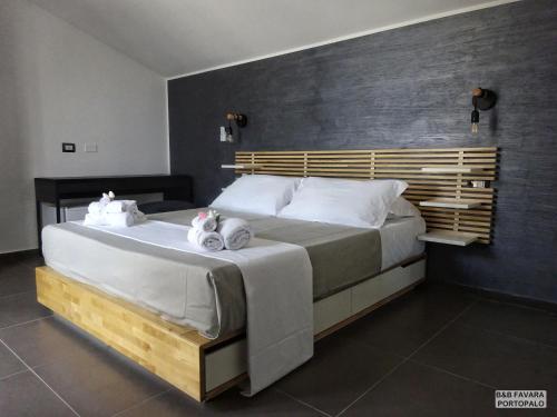 - une chambre avec un grand lit et des serviettes dans l'établissement FAVARA Rooms, à Portopalo di Capo Passero