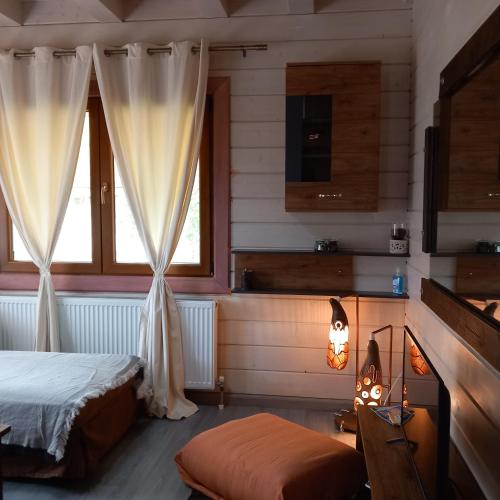 a bedroom with a bed and two windows at WOODEN HOUSE in Preveza