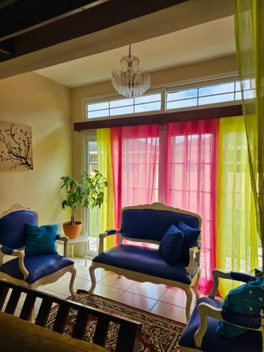 a living room with two chairs and a chandelier at Encanto Natural in Sambo Creek