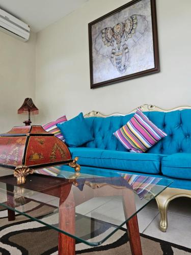 a living room with a blue couch and a glass table at Encanto Natural in Sambo Creek