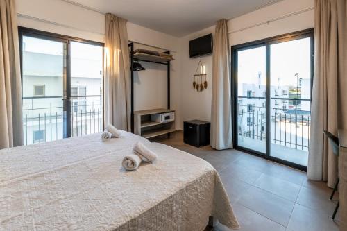 Un dormitorio con una cama y un balcón. en Hostal Alicante, en San Antonio