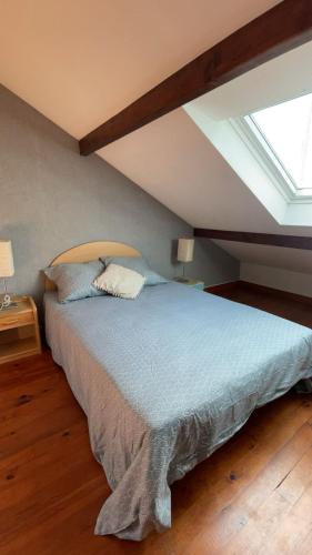 a bedroom with a large bed with a skylight at Chambre 24h Le Mans in Guécélard