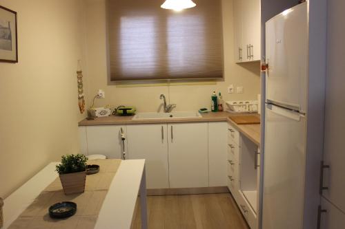 a kitchen with a white refrigerator and a sink at Yellow House close to the beach in Alikanas