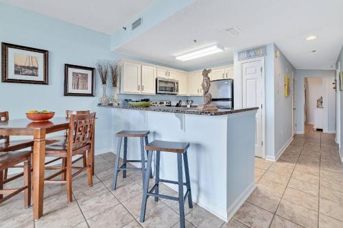 a kitchen with a bar and a table and chairs at Beach Club C-102 in Gulf Highlands
