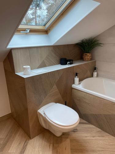 a bathroom with a toilet and a bath tub at Chambre 24h Le Mans in Guécélard
