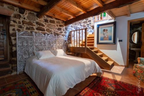 奧倫塞的住宿－Aloumiños do Ribeiro，一间卧室设有一张床和石墙