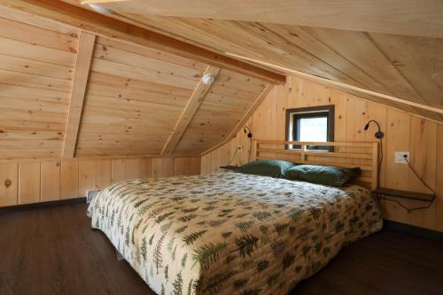 a bedroom with a bed in a wooden cabin at Chalets Lanaudière in Rawdon