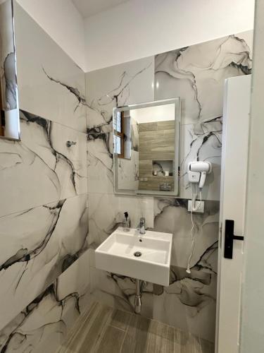 une salle de bain avec un lavabo et un miroir dans l'établissement Joen Apartment 2, à Saranda
