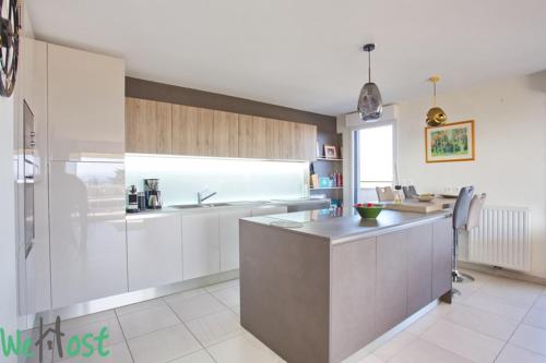 une cuisine avec des armoires blanches et un comptoir dans l'établissement Modernité & Vue Sainte Victoire, à Aix-en-Provence