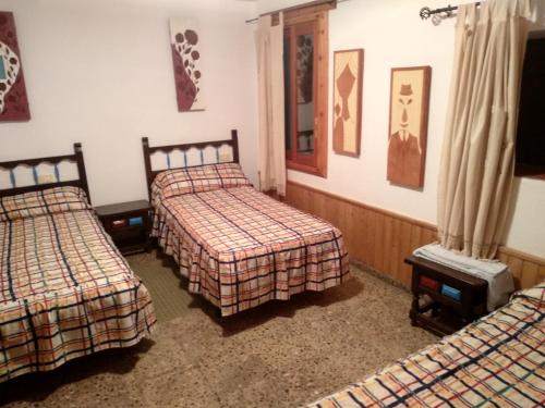 a room with three beds and a tv in it at Casa Demetrio in Mirambel