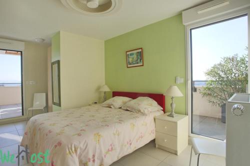 une chambre avec un lit et une grande fenêtre dans l'établissement Modernité & Vue Sainte Victoire, à Aix-en-Provence