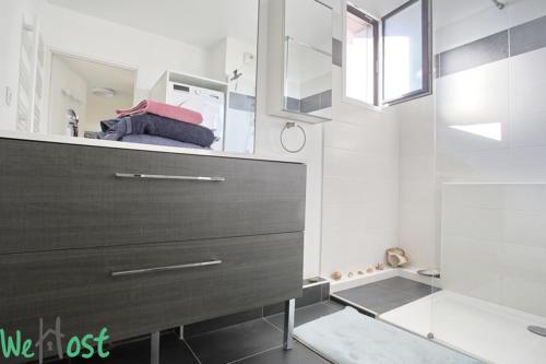 une salle de bain avec une commode marron et une douche dans l'établissement Modernité & Vue Sainte Victoire, à Aix-en-Provence