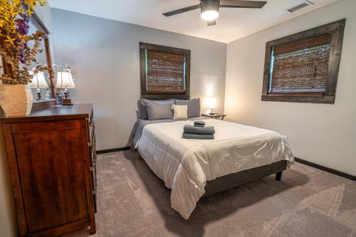 a bedroom with a bed and a dresser and two windows at New Listing! Boho Mountain Getaway - 2 Bed, 2 Bath in Dahlonega