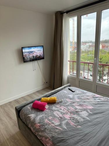 - une chambre avec un lit et une télévision murale dans l'établissement Chambre meublée à 10 minutes de Paris La Courneuve 1, à La Courneuve