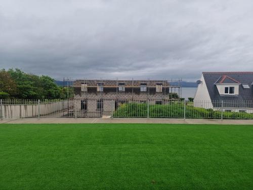 a building with a green lawn in front of it at Buncrana Beach House by Wild Atlantic Wanderer in Buncrana