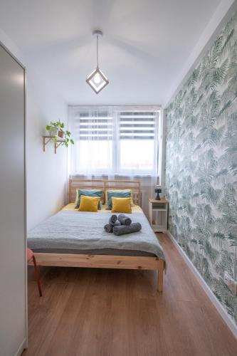 a bedroom with a large bed with yellow pillows at Verde Apartment SelfCheck-in 24h in Wrocław