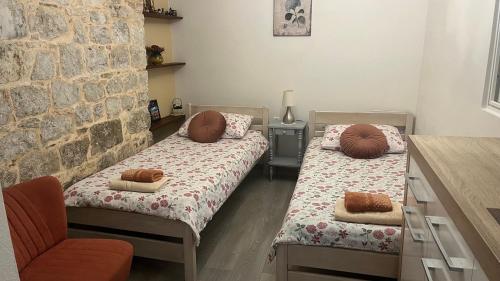 a room with two beds with pillows and a chair at Apartment Kova in Split