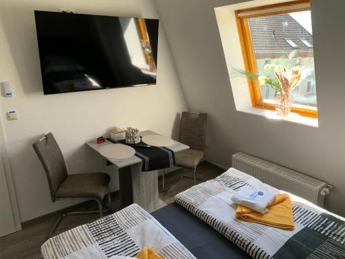 a room with two beds and a table and a window at -Fewo Benz- Exklusive Ferienwohnung im Stadtzentrum von Wittenberge Modernes Ambiente, 3 Einzelzimmer für bis zu 6 Gäste - voll ausgestattet mit Waipu-TV und High-Speed-WLAN Bettwäsche und Handtücher inklusive! in Wittenberge