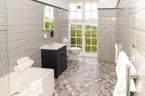 格蘭奇奧沃桑茨的住宿－坎布里亞郡大酒店，浴室配有盥洗盆、卫生间和浴缸。