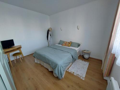 une petite chambre avec un lit et un bureau dans l'établissement Larmor-Plage T2 Notre-Dame, à Larmor-Plage