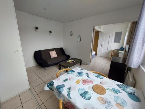 une petite pièce avec un lit et une table dans l'établissement Larmor-Plage T1bis Notre-Dame, à Larmor-Plage