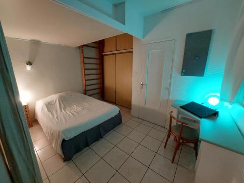 une petite chambre avec un lit et un bureau dans l'établissement Larmor-Plage T1bis Notre-Dame, à Larmor-Plage