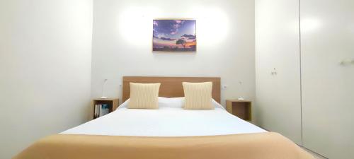- une chambre avec un grand lit et des draps blancs dans l'établissement Casa Nature, à Playa de Santiago